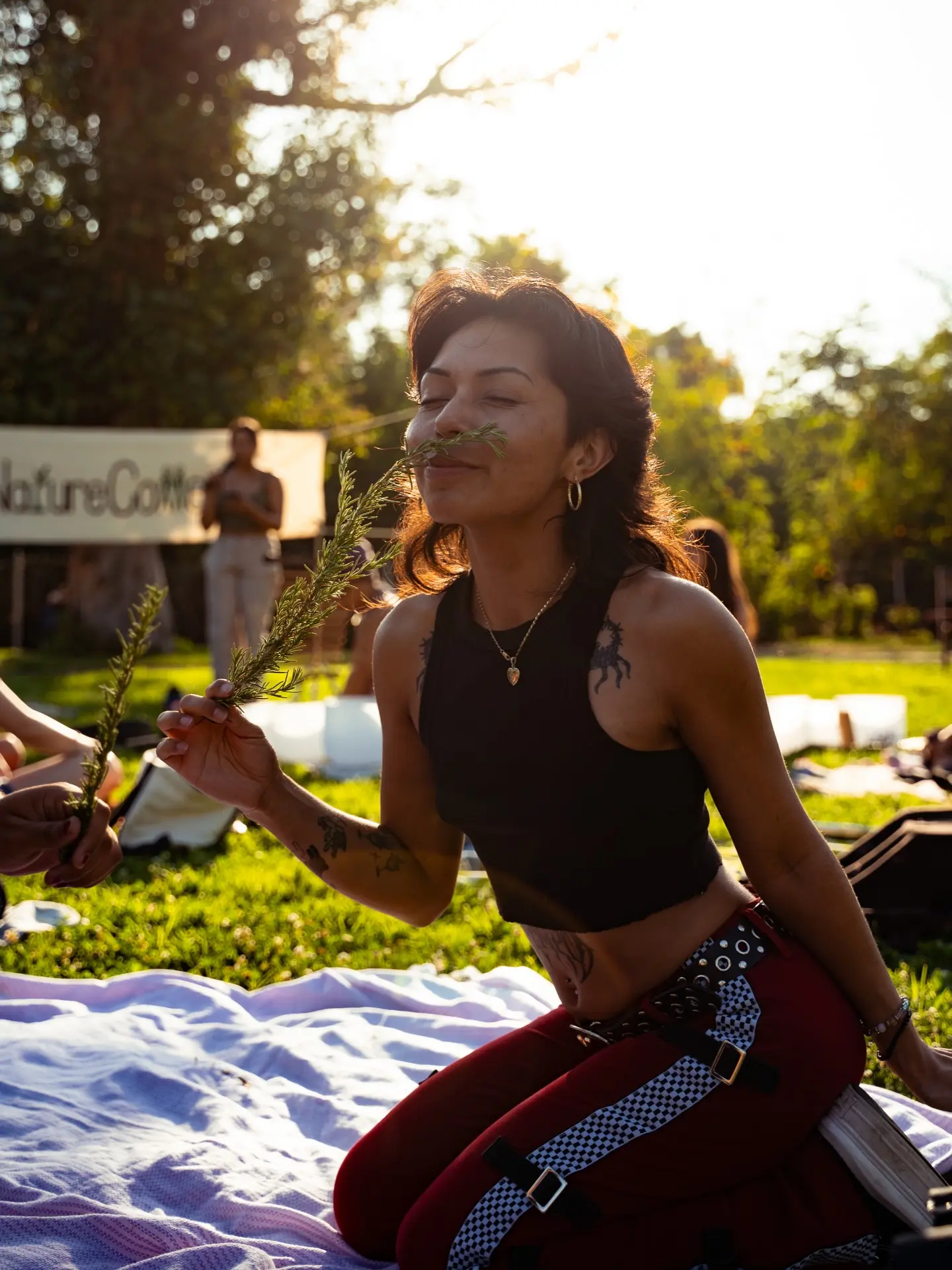A person smelling rosemary at a gathering